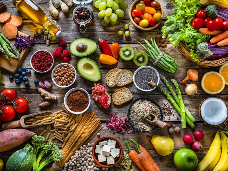 Gesundes Essen mit verschiedenen Sorten von Obst und Gemüse sowie Nudeln und Ölen