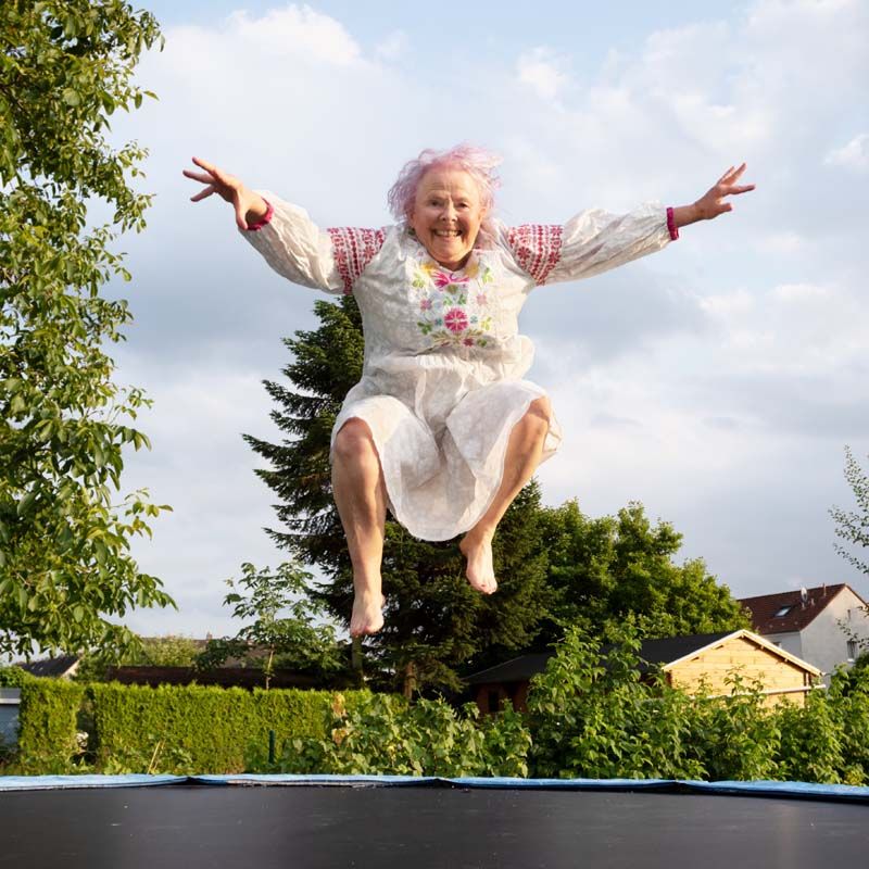 Ältere Frau die sich freut auf Trampolin